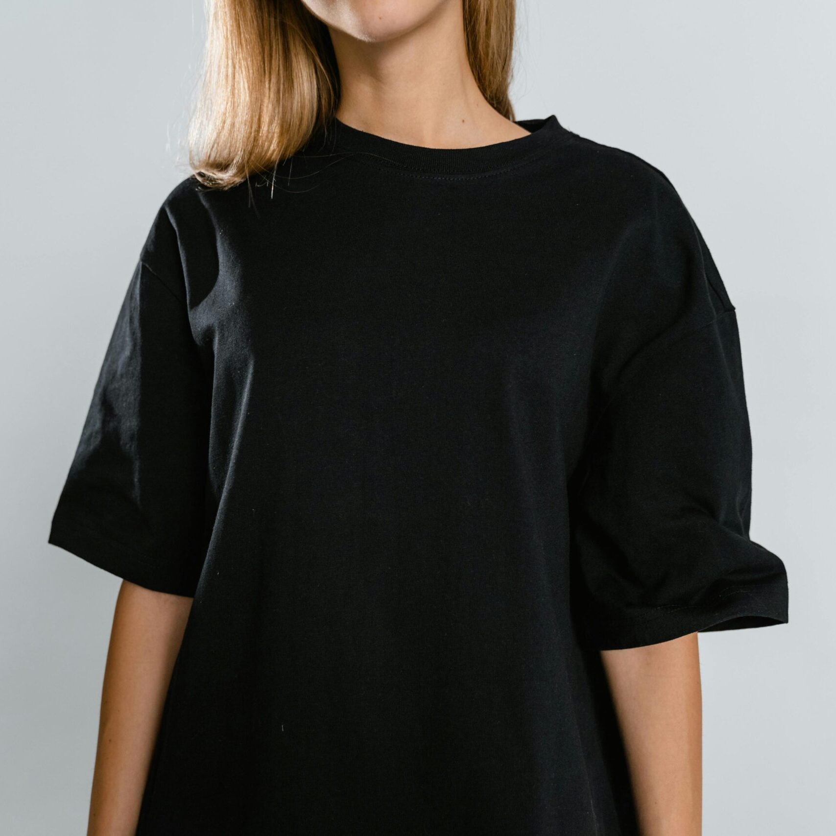 Front view of woman wearing black t-shirt with copy space on white background.